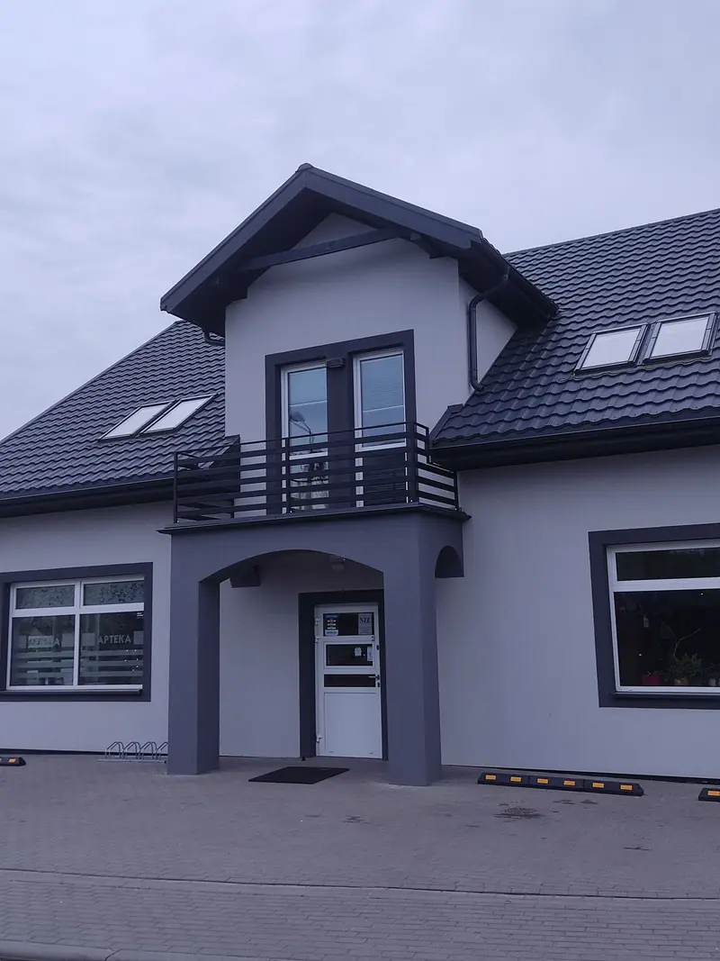 Balustrada z poziomych profili na balkonie nad wejściem do budynku