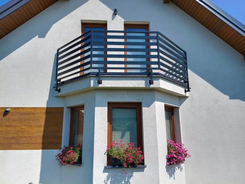 Balustrada z poziomych profili na balkonie nad wykuszem, widok z przodu