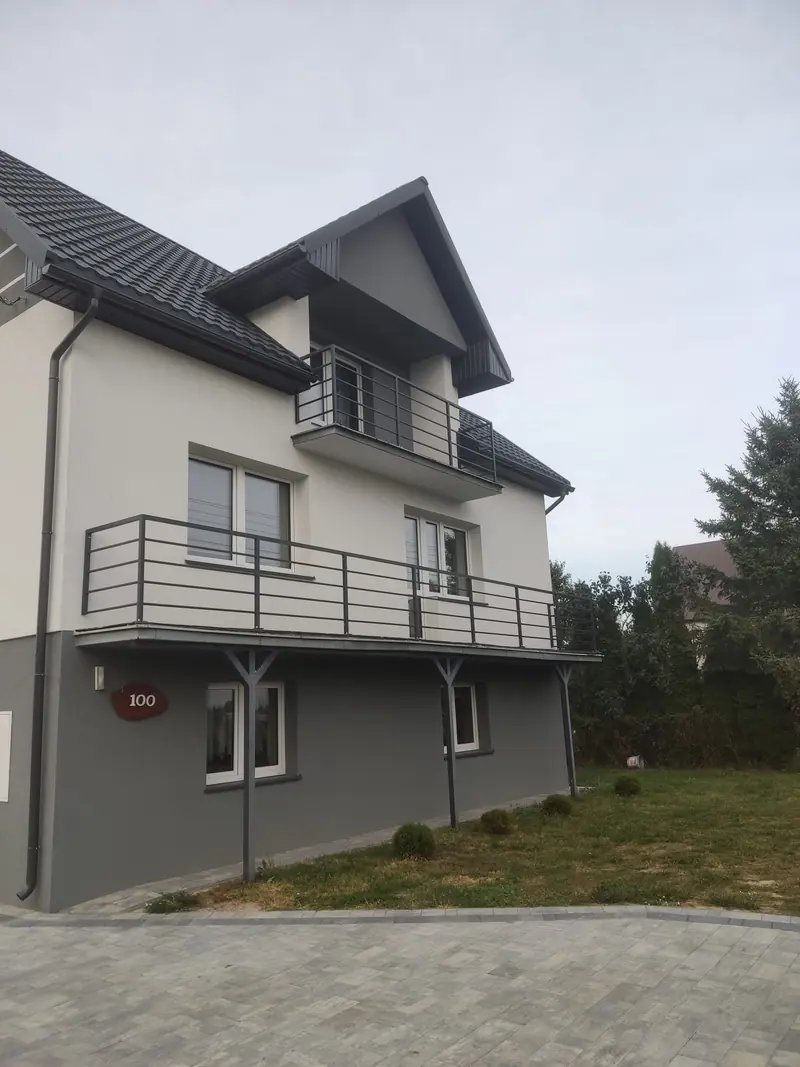 Balustrady z poziomych prętów stalowych na dwóch balkonach domu jednorodzinnego