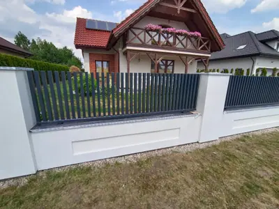 Przęsła ogrodzenia z pionowych profili stalowych na tynkowanej podmurówce