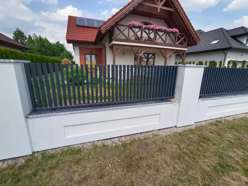 Przęsła ogrodzenia z pionowych profili stalowych na tynkowanej podmurówce