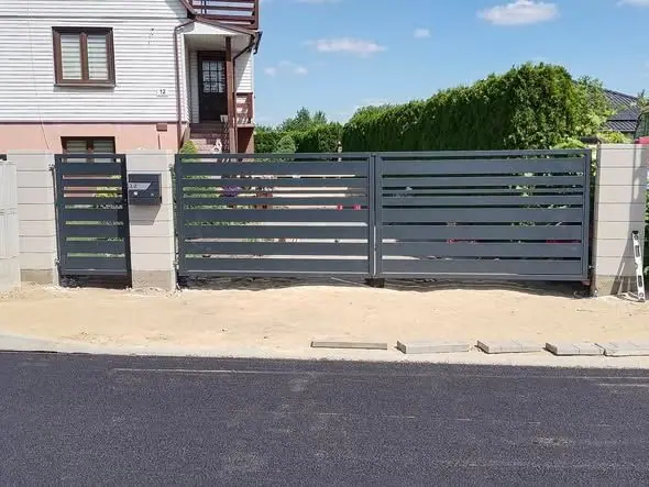 Brama skrzydłowa i furtka z poziomych profili stalowych między słupkami ogrodzenia z bloczków