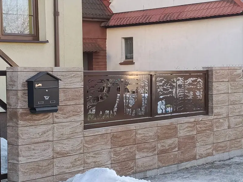 Przęsła z blachy stalowej z ażurowym motywem jeleni w murowanym ogrodzeniu z bloczków