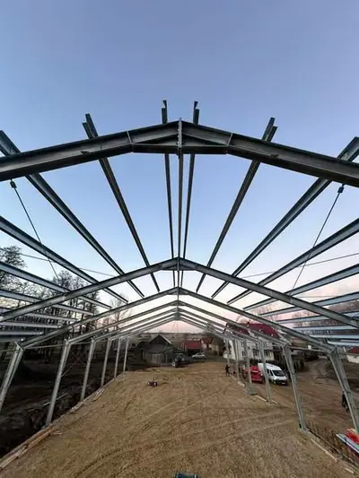 Szkielet hali stalowej z dachem dwuspadowym i płatwiami, widok wzdłuż hali